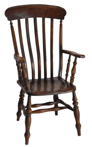 A late Victorian stained beech lath back arm chair, with high back and turned spindle supports to the arm, and legs and stretchers below.