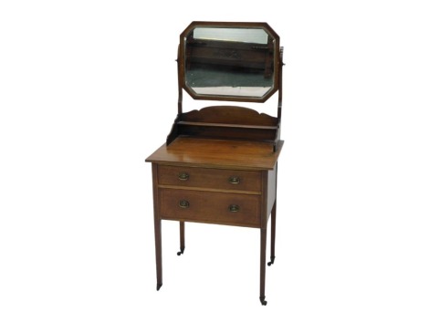 An early 20thC mahogany Sheraton revival dressing chest, of small proportions, with octagonal bevelled mirror, with narrow shelf below, and the table base fitted with two graduated drawers, having small brass shaped oval handles, on square legs, with cast