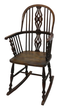 An elm and yew Windsor rocking chair, with pierced and shaped splat backs and spindle supports.