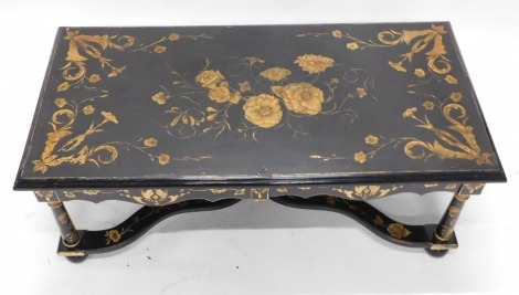 An 18thC Dutch style faux marquetry low centre table, ebonised and with applied gilt flower head and scrolling foliate motifs, with shaped frieze, on tapered legs and with scrolling cross frame stretchers, on bun feet, 125cm x 64cm.