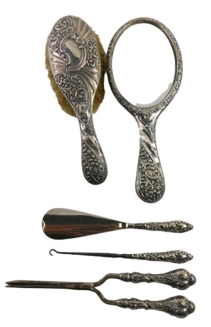 A Victorian and later silver five piece matched dressing table set, comprising mirror and brush, Birmingham 1899, glove stretchers, shoe horn, and button hook. (5)