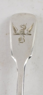 Two silver spoons, comprising a silver Art Deco style teaspoon with scroll terminal and a William IV dessert spoon, bearing griffin crest and the letter B, maker WT, London 1830, 1.47oz. (2) - 2