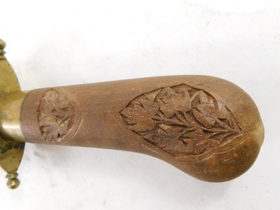 A Middle Eastern dagger, the wooden carved handle depicting flowers and vines, on a stainless steel curved blade, 27cm long. - 2