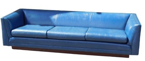 A large blue leather upholstered sofa, with three loose cushions, on a plinth, 245cm wide. The upholstery in this lot does not comply with the 1988 (Fire & Fire Furnishing) Regulations, unless sold to a known exporter or upholsterer it will be cut from th