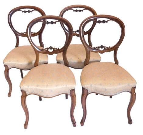 A set of Victorian rosewood balloon back chairs, the backs carved with small flower heads and with over upholstered seat in beige and blue silk fleur de lys pattern material, on stylised French cabriole legs.