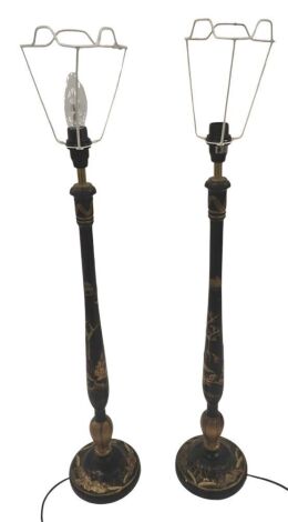 A pair of Japanned table lamps, each decorated in gilt with Oriental figures, landscapes, etc., on a black ground, 75cm high to top of fitting. (AF) WARNING! This lot contains untested or unsafe electrical items. It is supplied for scrap or re-conditioni