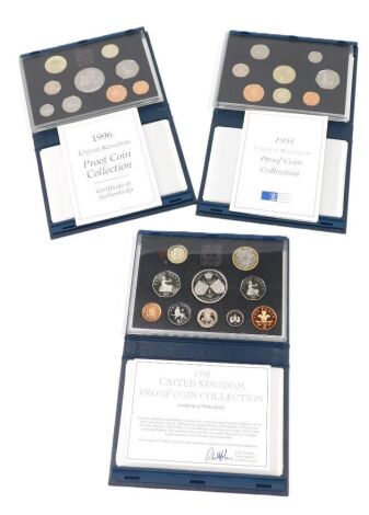 Three cased coin sets, two for 1995, and one for 1997. (3)