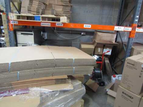 The entire bay of packaging related boxes and portable banding machine, and a large quantity of flatpack boxes.