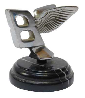 A 1930s Bentley flying B car mascot, mounted on a black marble base, 9cm high.