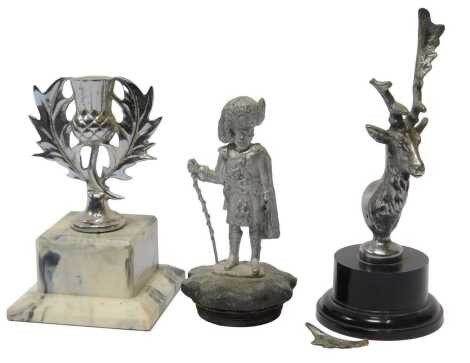 Three chromed car mascots, including a thistle mounted on a marble base, a Black Watch solider mascot, and a stag. (3)