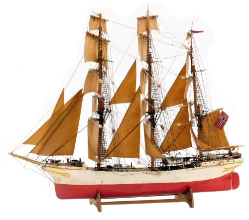 An early 20thC wooden scale model of a Norwegian sailing ship, "Heltodos", with a wooden hull, three fully rigged masts and sails, on a wooden cradle, 72cm wide.