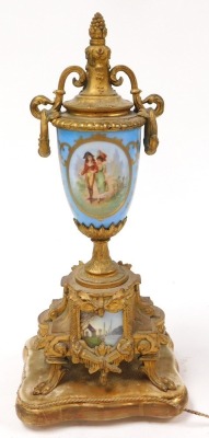 A late 19thC French brass and porcelain clock garniture, the clock with circular porcelain dial, painted with Arabic numerals, eight-day movement, with bell strike, the case with an urn finial, central plaque painted with a courting couple, raised on four - 2