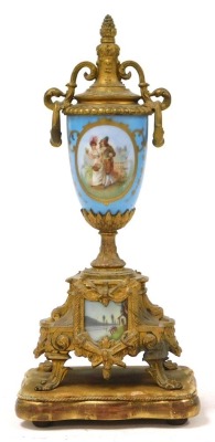 A late 19thC French brass and porcelain clock garniture, the clock with circular porcelain dial, painted with Arabic numerals, eight-day movement, with bell strike, the case with an urn finial, central plaque painted with a courting couple, raised on four - 4