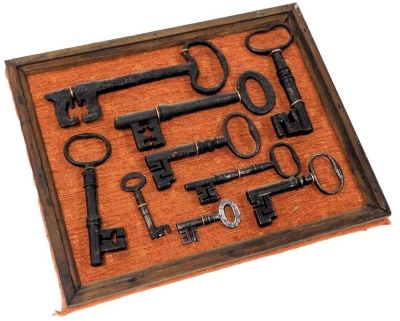 A group of 18thC and later cast iron door keys, framed, frame 28cm wide.