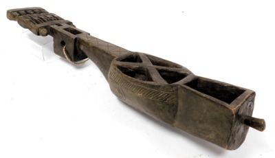 A 19thC Eastern Indian Santal lute, Dhaodro Banam, of carved wood, the headstock carved with five standing figures, with interlocking arms, resonator hide lacking, 79cm high. - 2