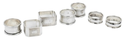 Seven silver napkin rings, five circular and two octagonal, of plain form or with engine turned decoration, 4.36oz.