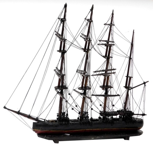 A wooden scale model of a four masted sailing ship, fully rigged, without sails, raised on an integral base, 65cm wide.