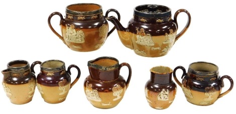 A group of Doulton Lambeth stoneware two tone harvest tea wares, most with silver rims, comprising a teapot, three cream jugs, two sugar bowls, together with a doubled lipped jug. (7)