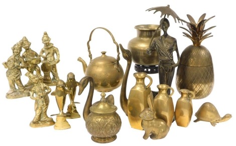 A group of brassware, including four figures of clowns, dolphins, a pineapple container, tea kettle, and three graduated jugs.