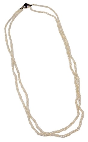 A double strand of seed pearls, on a yellow metal box clasp, set with an amethyst.