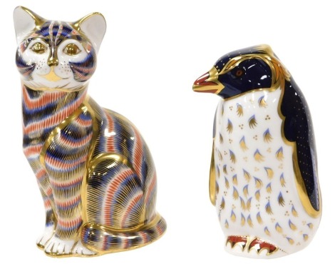 A Royal Crown Derby Imari Rock Hopper penguin paperweight designed by John Ablitt, together with a further paperweight, modelled as a seated cat, both with gold stoppers. (2)