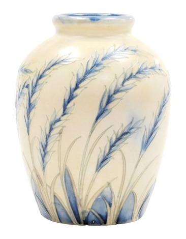 An early 20thC Moorcroft pottery vase decorated in the Waving Corn pattern, blue colourway, impressed and painted marks, 15.5cm high.