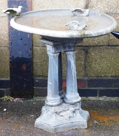 A lead birdbath, the circular top surmounted by three birds, raised on a triple column support, on a trefoil base, 73cm high, 65cm wide. (AF)