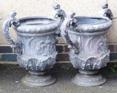 A pair of lead twin handled garden urns, with leaf scroll handles, the body decorated with a frieze of classical figures, 63cm high.