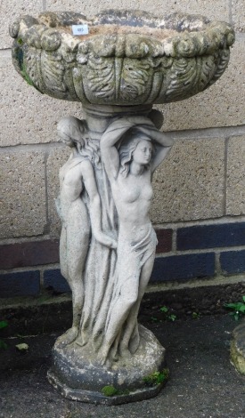 A concrete birdbath, the circular leaf moulded bowl raised on a figural Three Graces column above a hexagonal base, 82cm high.