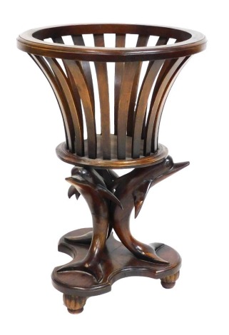 A mahogany jardiniere, with a slatted out swept top, raised on three dolphin supports over a trefoil base and fluted feet, 72cm high, 50cm wide.