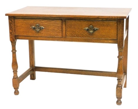 An early 20thC oak side table, with two frieze drawers, raised on baluster turned supports, united by a three sided box stretcher, 76cm high, 103cm wide, 51cm deep.