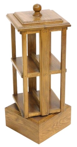 A 20thC oak revolving bookcase, two tier and two sectional, raised on a plinth base, 71cm high, 27cm wide, 27cm deep.