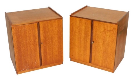 A pair of mid century Dynatron Radio Limited teak record cabinets, with two doors opening to reveal a record player shelf, above six recesses for LPs, 58cm high, 52cm wide, 42cm deep.