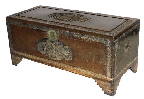 An early 20thC Chinese camphor wood chest, with a figural carved hinged lid, and front, the borders carved with flowers, raised on bracket feet, 54cm high, 120cm wide, 52cm deep.