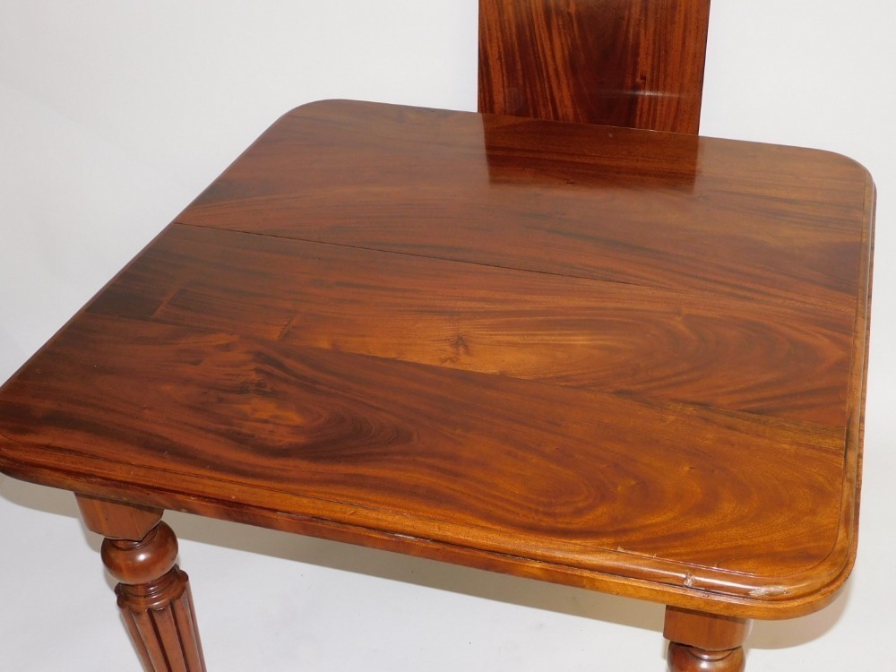 A Victorian mahogany wind out dining table, with one additional leaf ...
