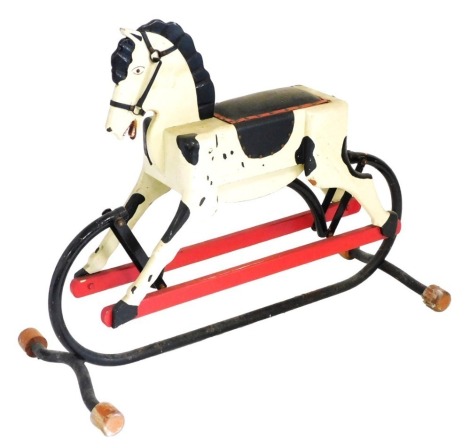 A 20thC carved wooden rocking horse, on a cast iron frame, with leather saddle, 105cm wide.