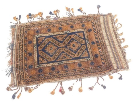 A Caucasian brown ground travelling saddle rug, with a rectangular central field containing two medallions, within repeating floral and dog tooth borders, 100cm x 64cm.