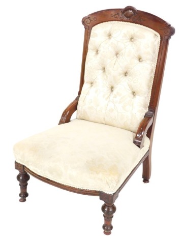 A Victorian mahogany nursing chair, upholstered in cream floral button back upholstery, raised on turned legs, on castors, 63cm wide.