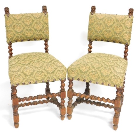 A pair 17thC style oak dining chairs, with overstuffed seat and back, covered in green and gold floral upholstery, raised on turned legs, united by spiral twist uprights and stretchers.