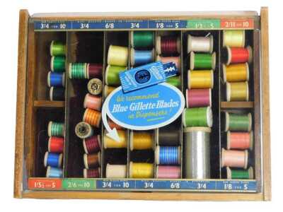 A 20thC oak Gillette display case, with a hinged top, with various compartments for different sized blades, containing reels of thread, 38.5cm wide.