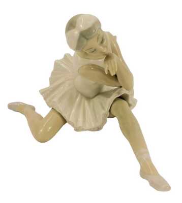 A Lladro porcelain figure, modelled as a seated ballerina, 12cm high, boxed.