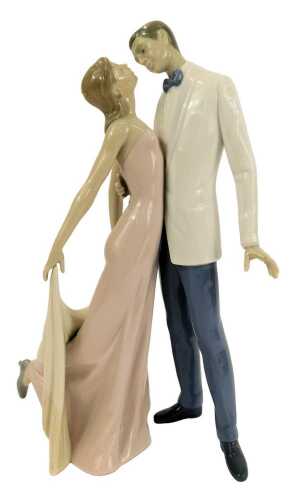 A Lladro porcelain figure group, modelled as a lady and gentleman in formal dress embracing, printed marks, 32cm high.