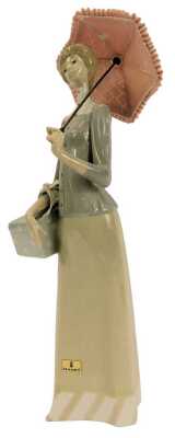 A Lladro porcelain figure, modelled as a lady holding a parasol and box, printed marks, 37cm high.