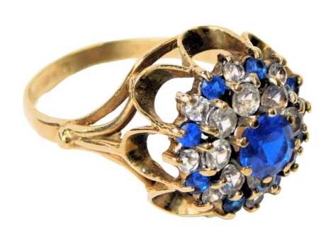 A 9ct gold set flower head ring, set with blue and white stones, in a scroll setting, size O, 4.3g.