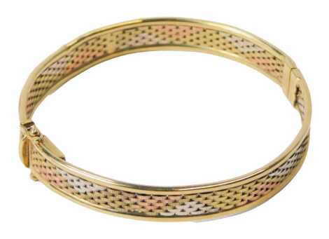 A 9ct three colour gold bangle, on a snap clasp, 14.2g.