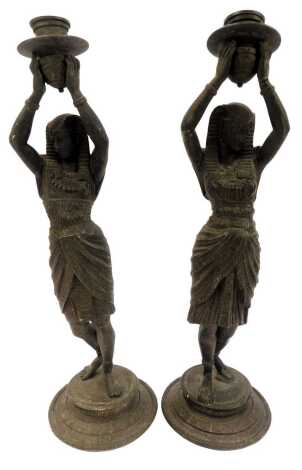 A pair of spelter figural candlesticks, each modelled as a lady in Egyptian dress with arms raised, on circular base, 40cm high.