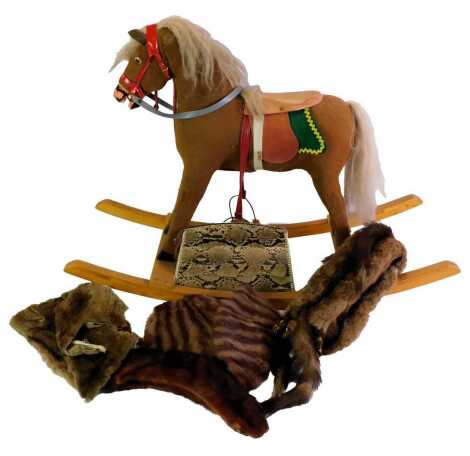 A 20thC rocking horse, with felt covering, on a wooden base, 60cm high, together with a snakeskin clutch bag and various furs.