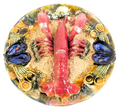 A 20thC Portugese Majolica lobster plate, decorated to the border with shells and seaweed, 32cm diameter. (AF)