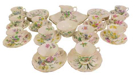 A Royal Albert porcelain Flower of the Month series tea service, comprising a pair of bread plates, cream jug and sugar bowl, twelve tea cups, saucers and plates.