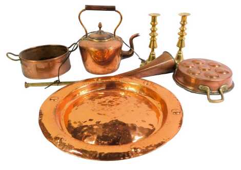 A group of copper and brassware, to include a hammered brass charger with roundel decoration to border, 40cm diameter, a Victorian copper kettle, pair of brass candlesticks, copper and brass hunting horn, etc. (a quantity)